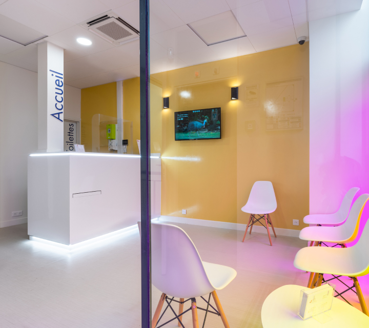 Salle d'attente moderne avec chaises blanches mur jaune et écran TV - centre sembat boulogne | Imagerie Cardinet | Région Parisienne