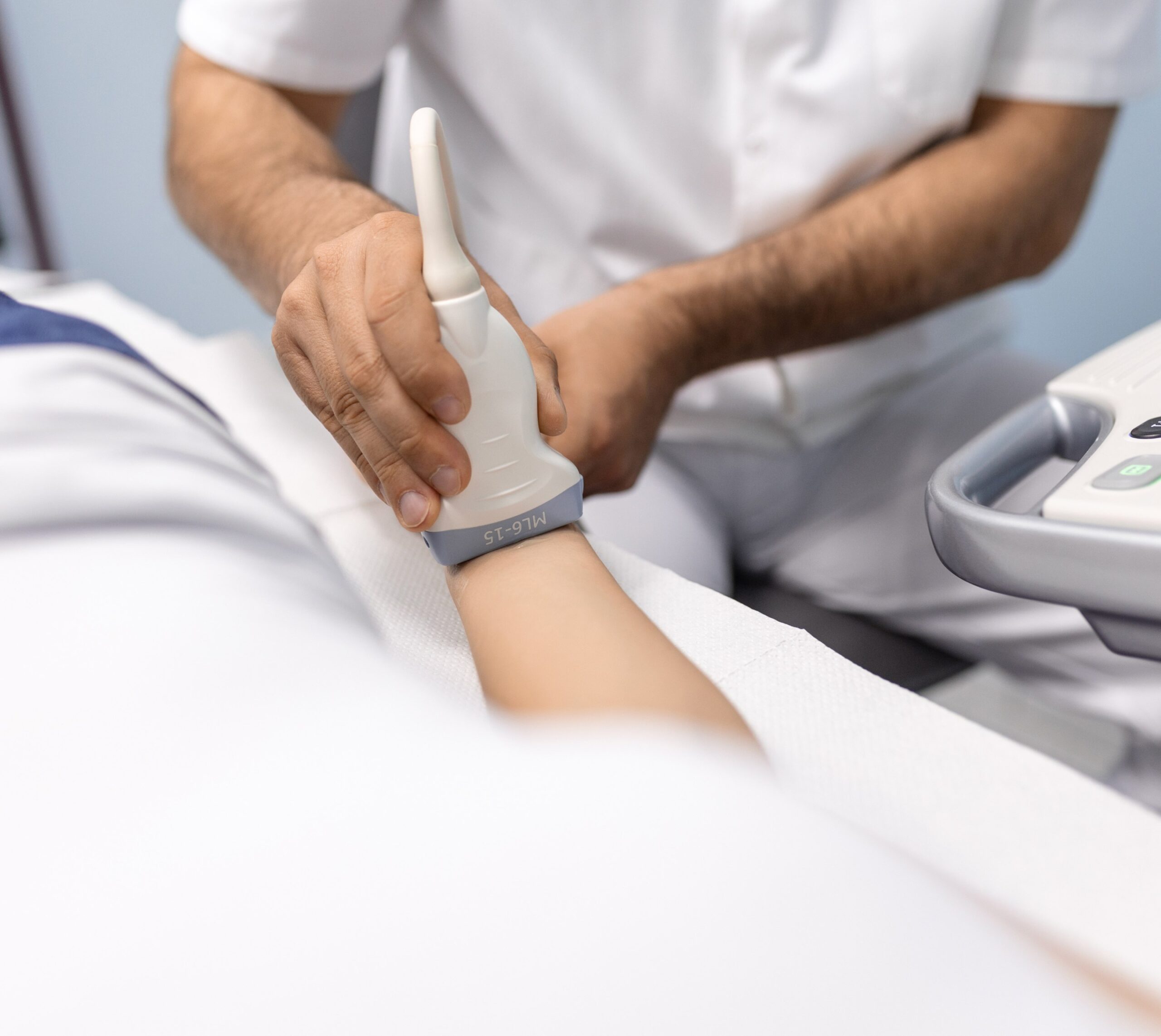 Radiologue utilise un appareil d'échographie sur le bras d'un patient - Doppler | Imagerie Cardinet | Région Parisienne