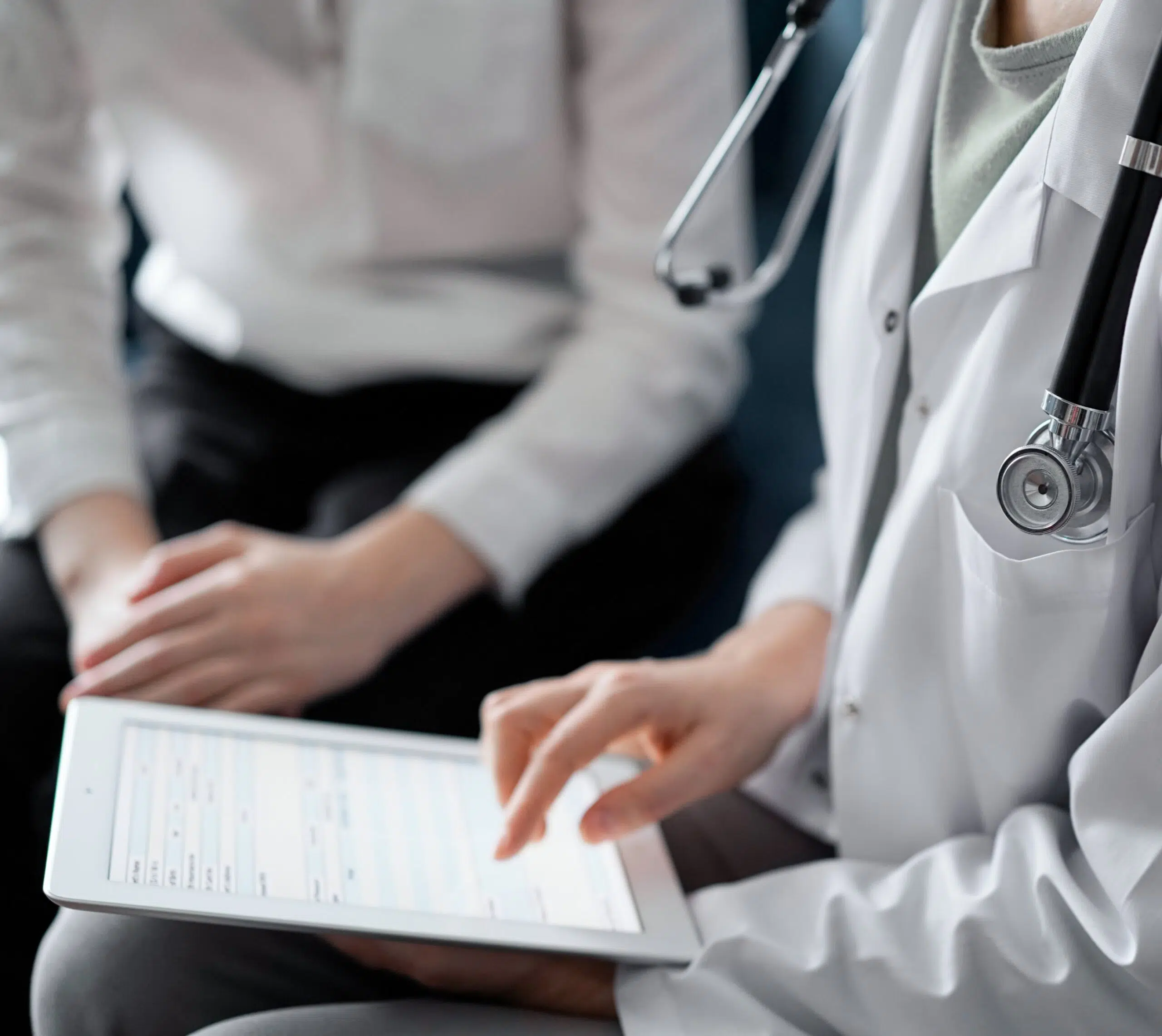 Médecin utilise une tablette discutant avec une autre personne | fertilité masculine | Imagerie Cardinet | Région Parisienne