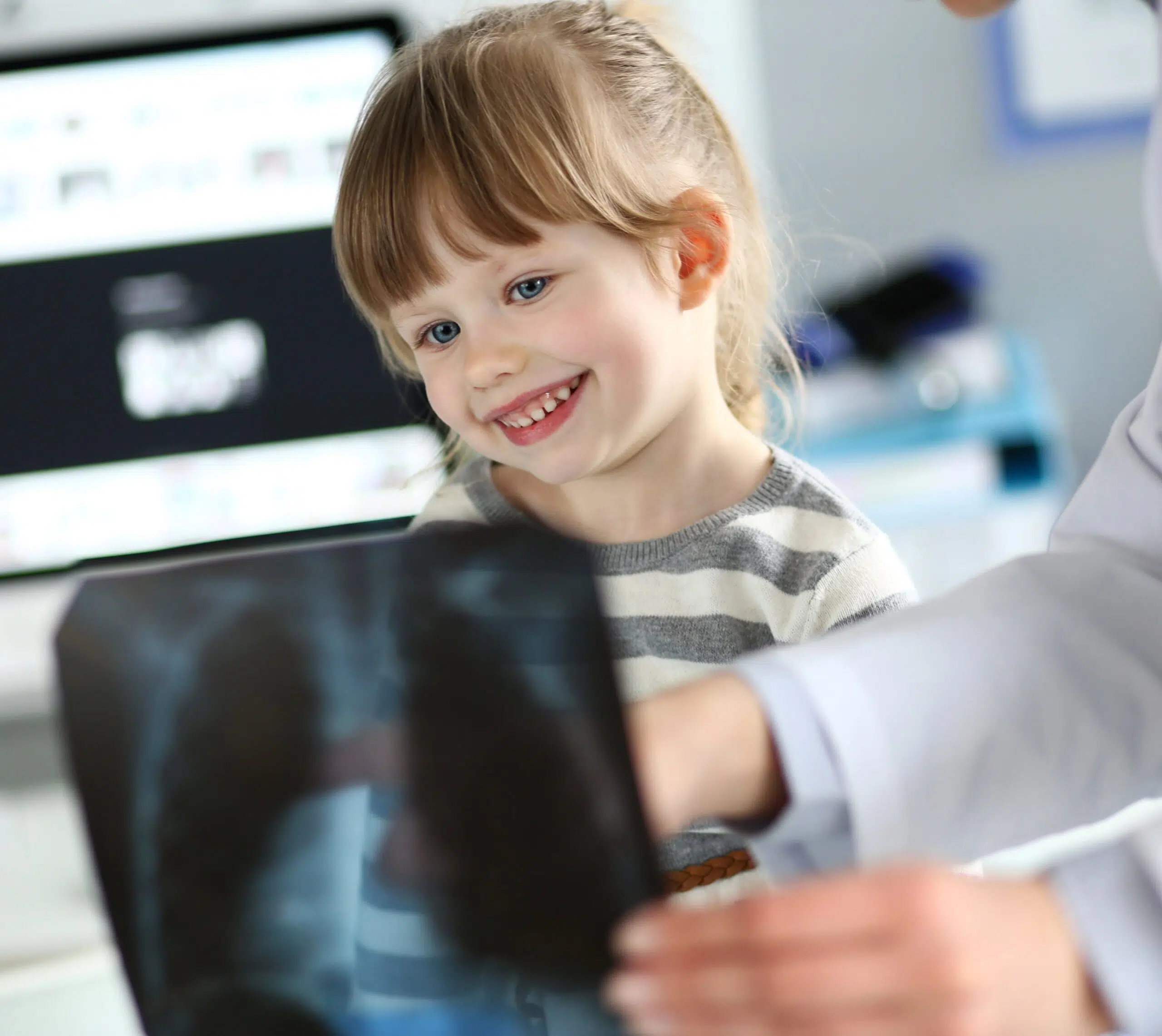 Médecin tenant une radiographie devant un enfant - radiopédiatrie | Imagerie Cardinet | Région Parisienne