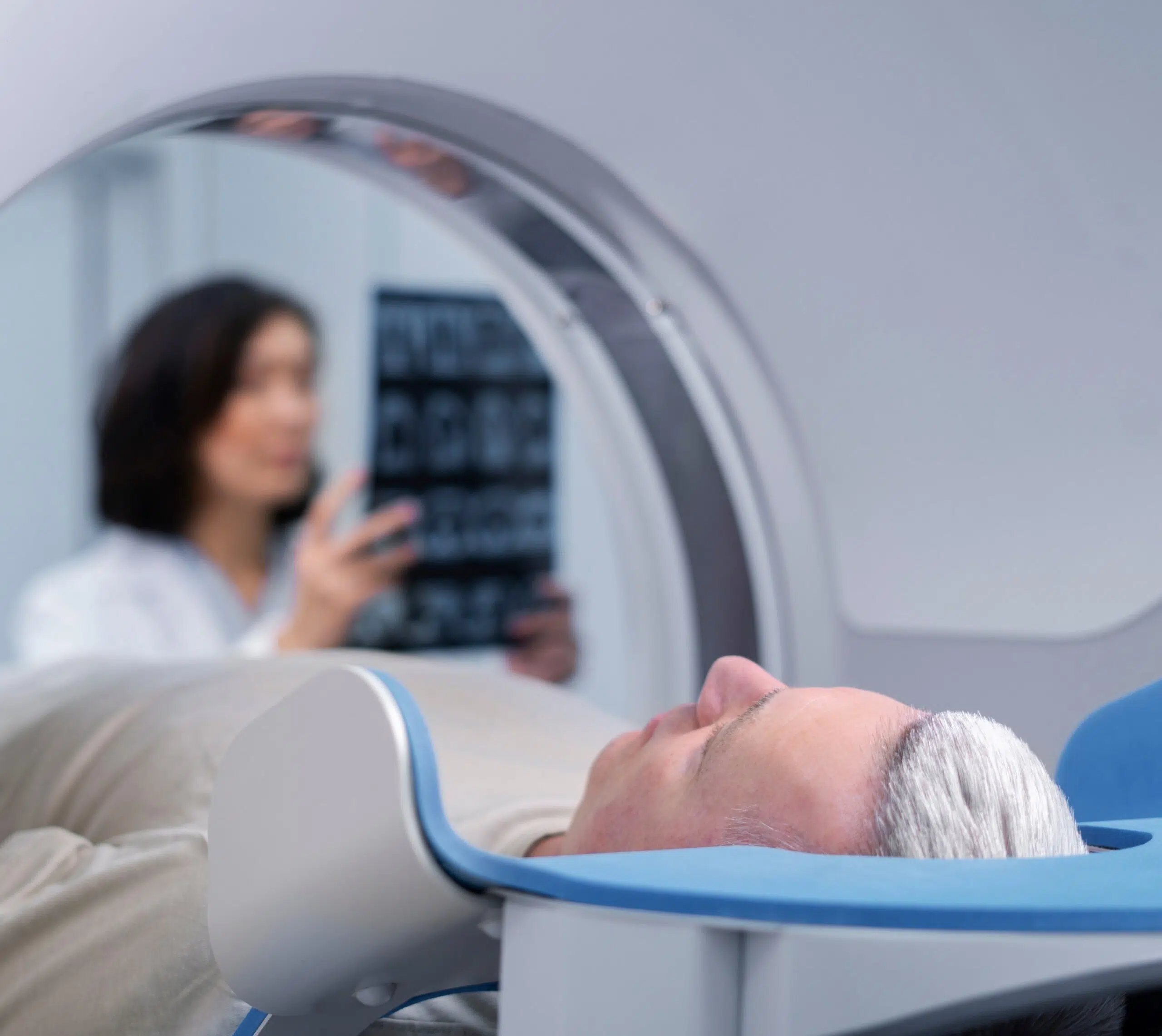 Homme allongé sur une table d'examen médical entrant dans un scanner - IRM cérébrale | Imagerie Cardinet | Région Parisienne