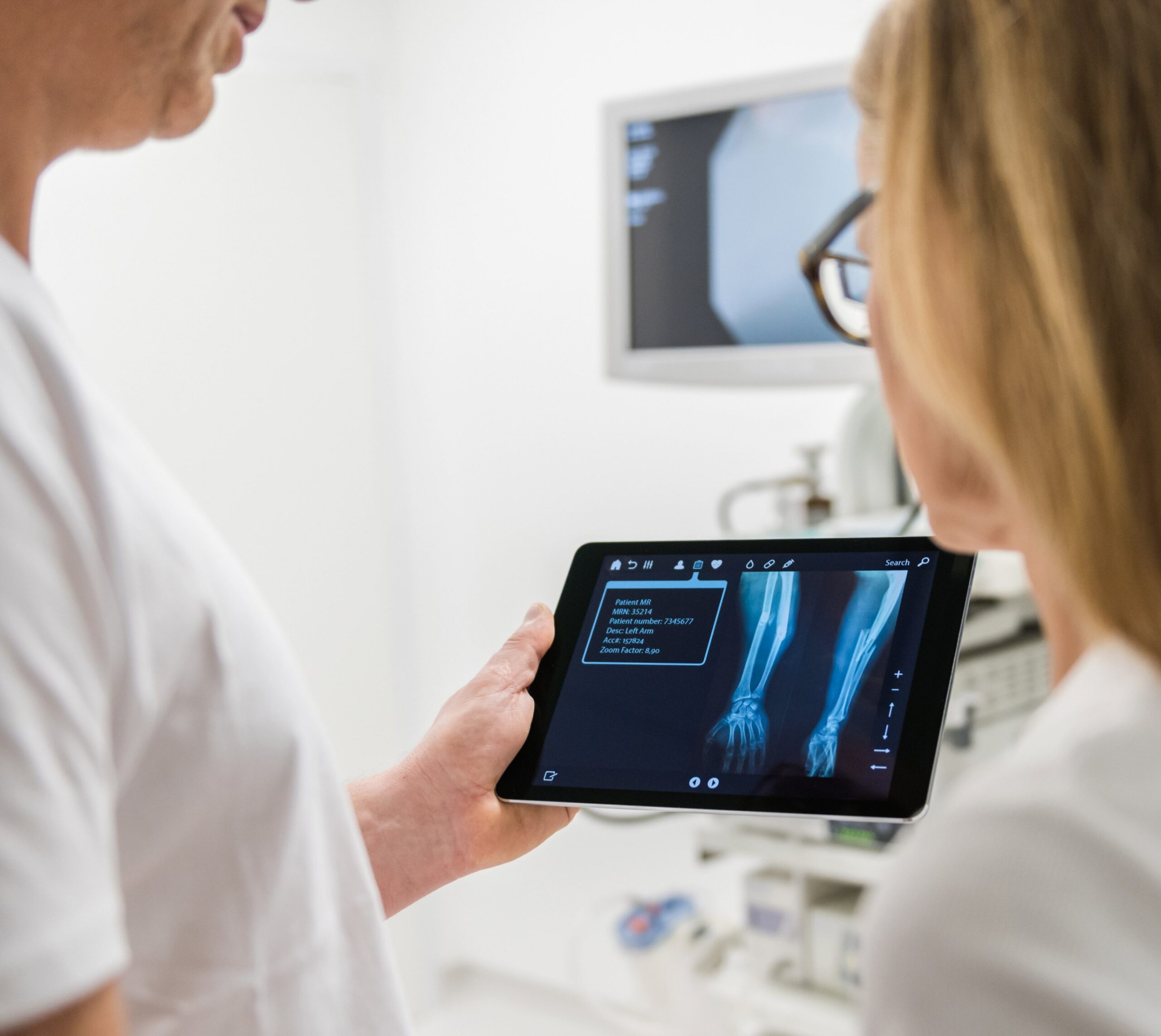 Deux médecins regardent une radiographie de bras sur une tablette - radiographie des membres | Imagerie Cardinet | Région Parisienne
